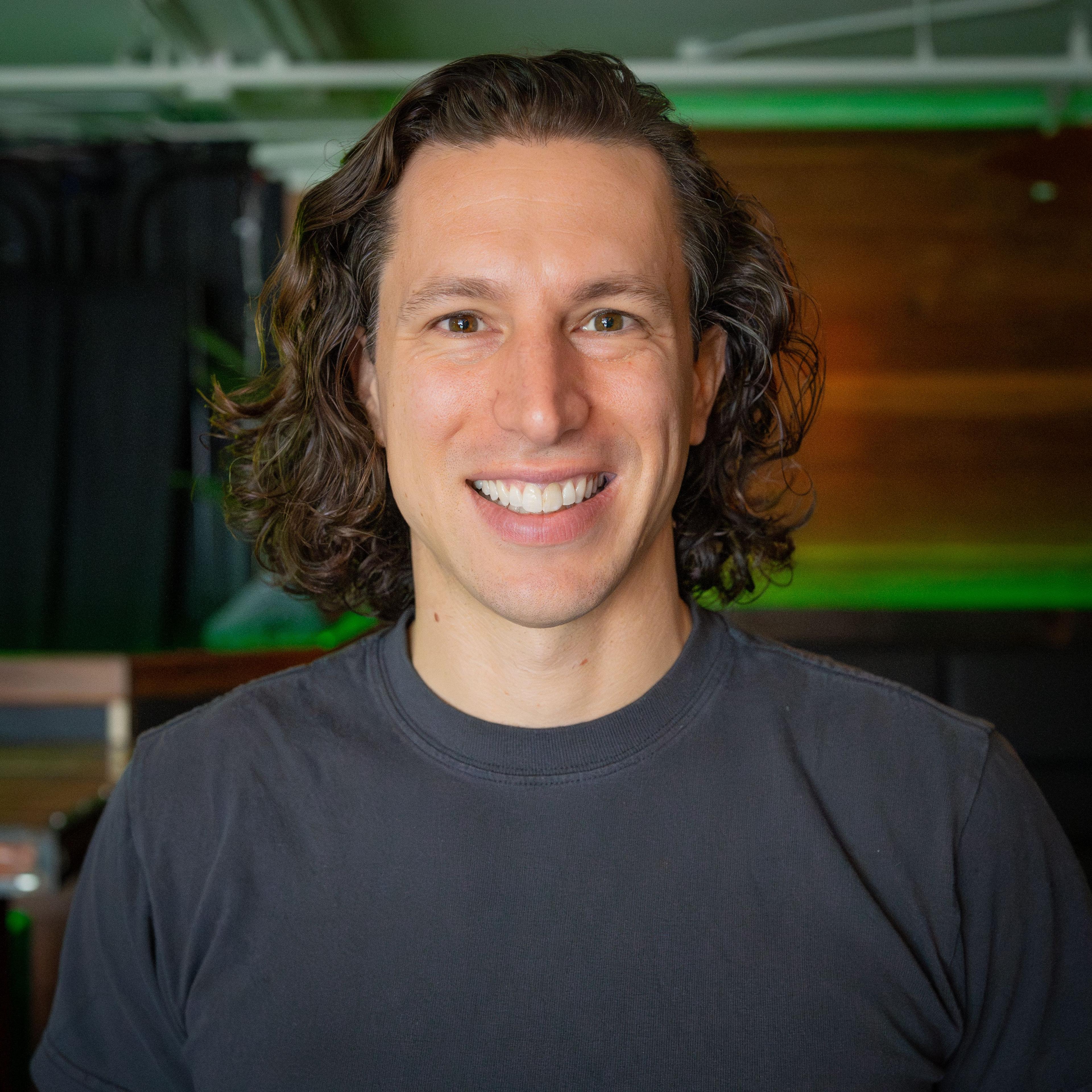 Headshot of a smiling man with long, wavy brown hair.Rosenthal