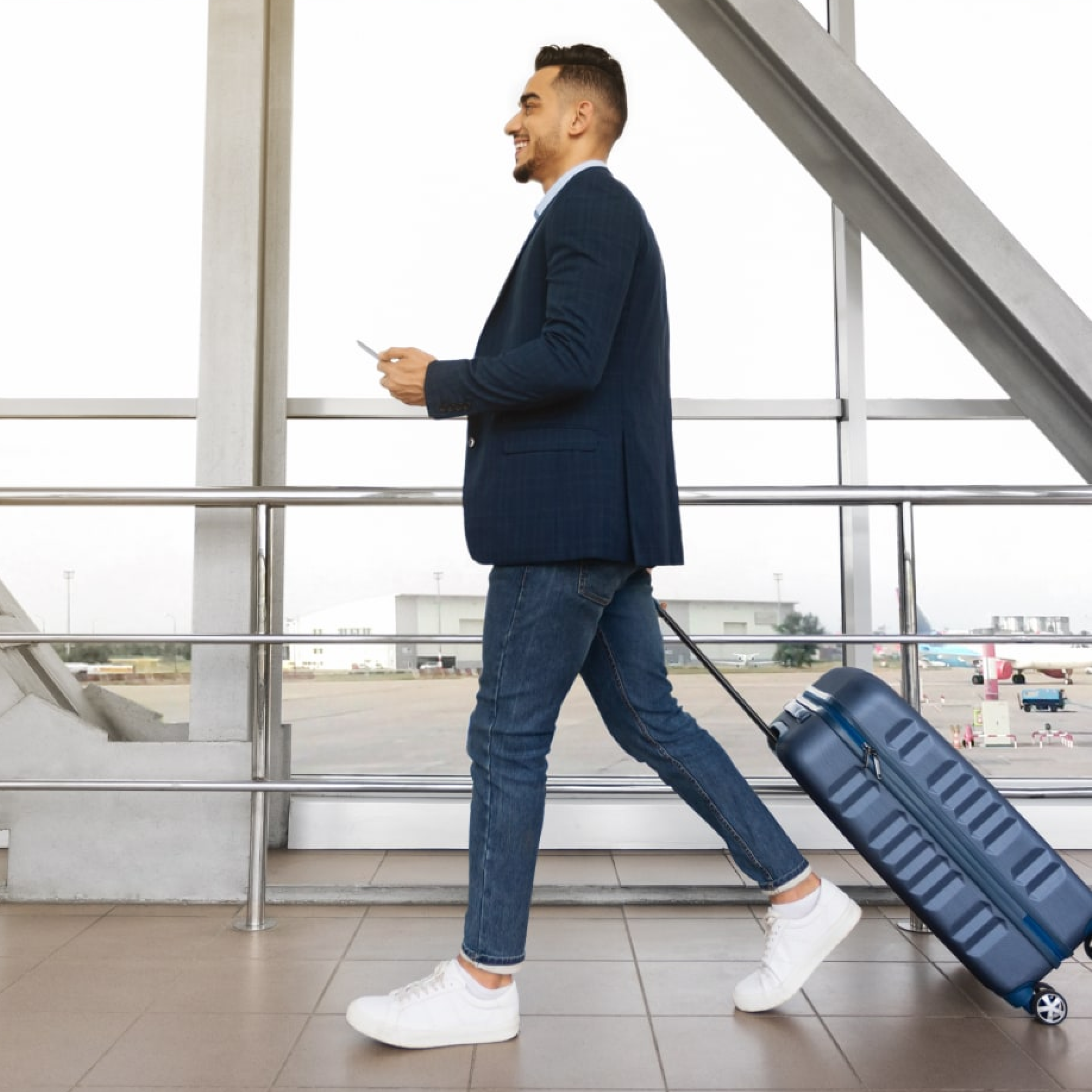 Man walking through airport with suitcase
