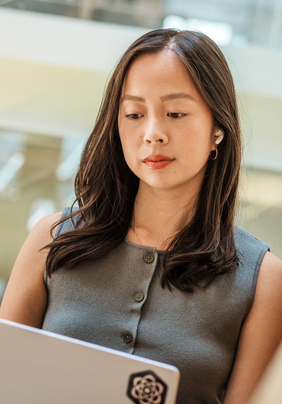 Girl working on laptop with air pods in