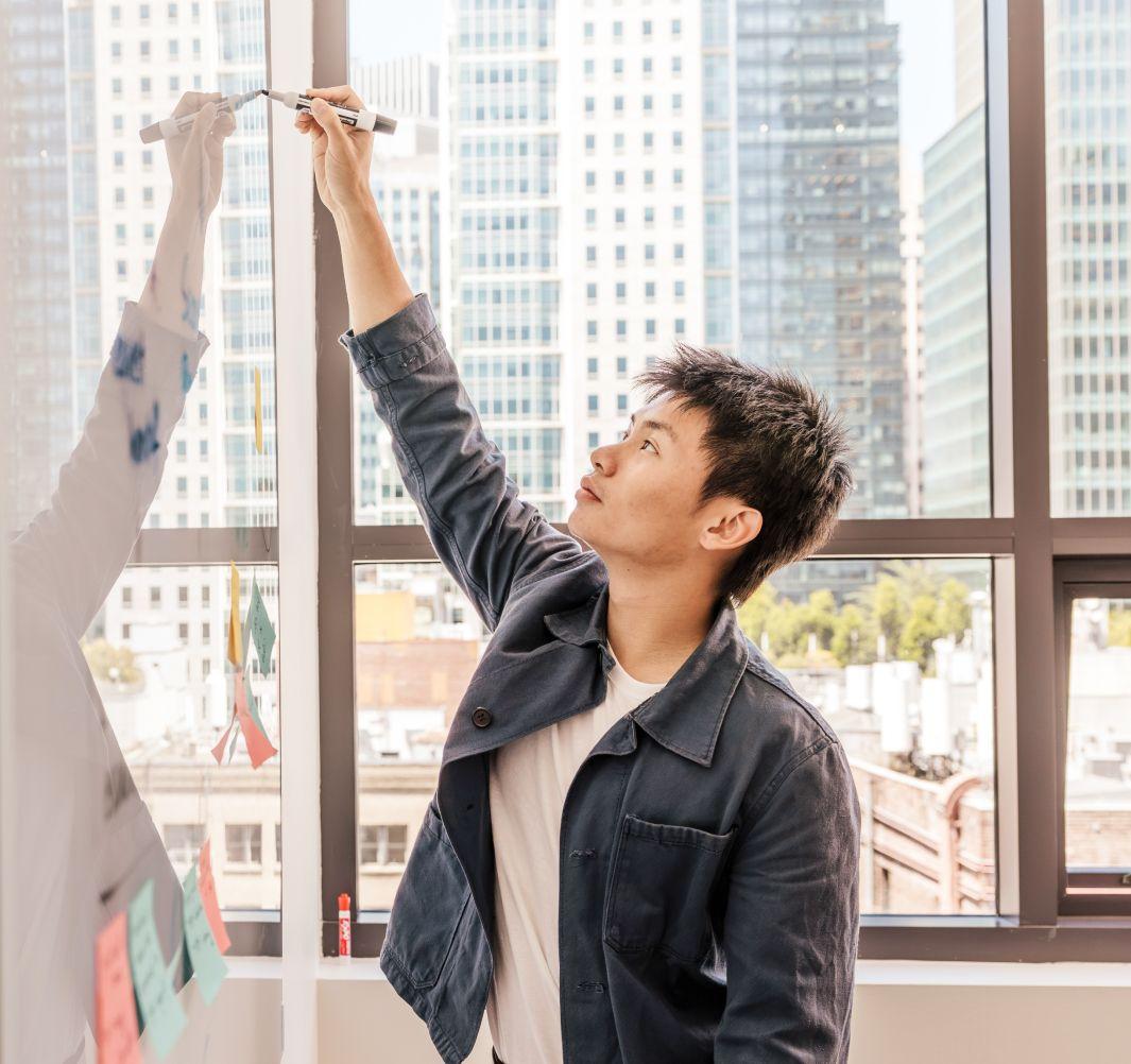 a man writing on a white board