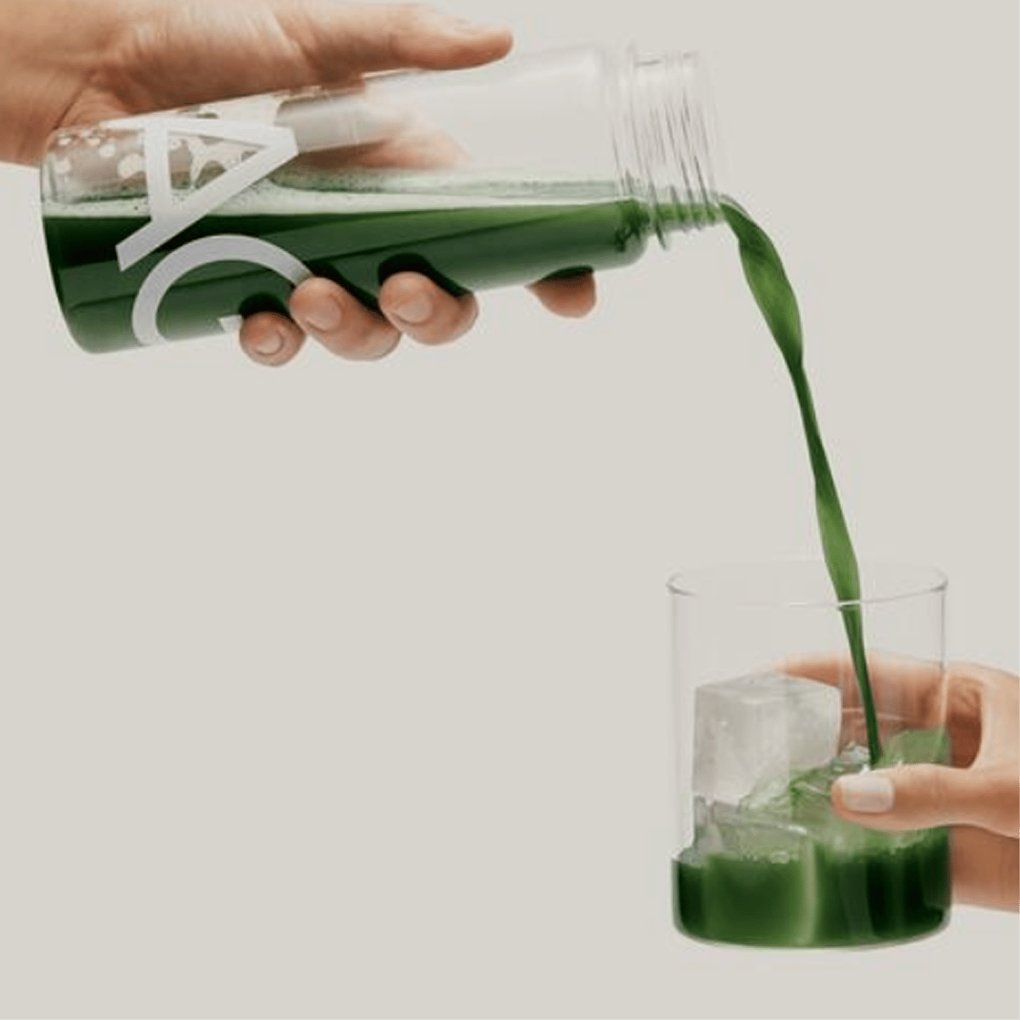 Pouring a bottle of AG1 into a glass