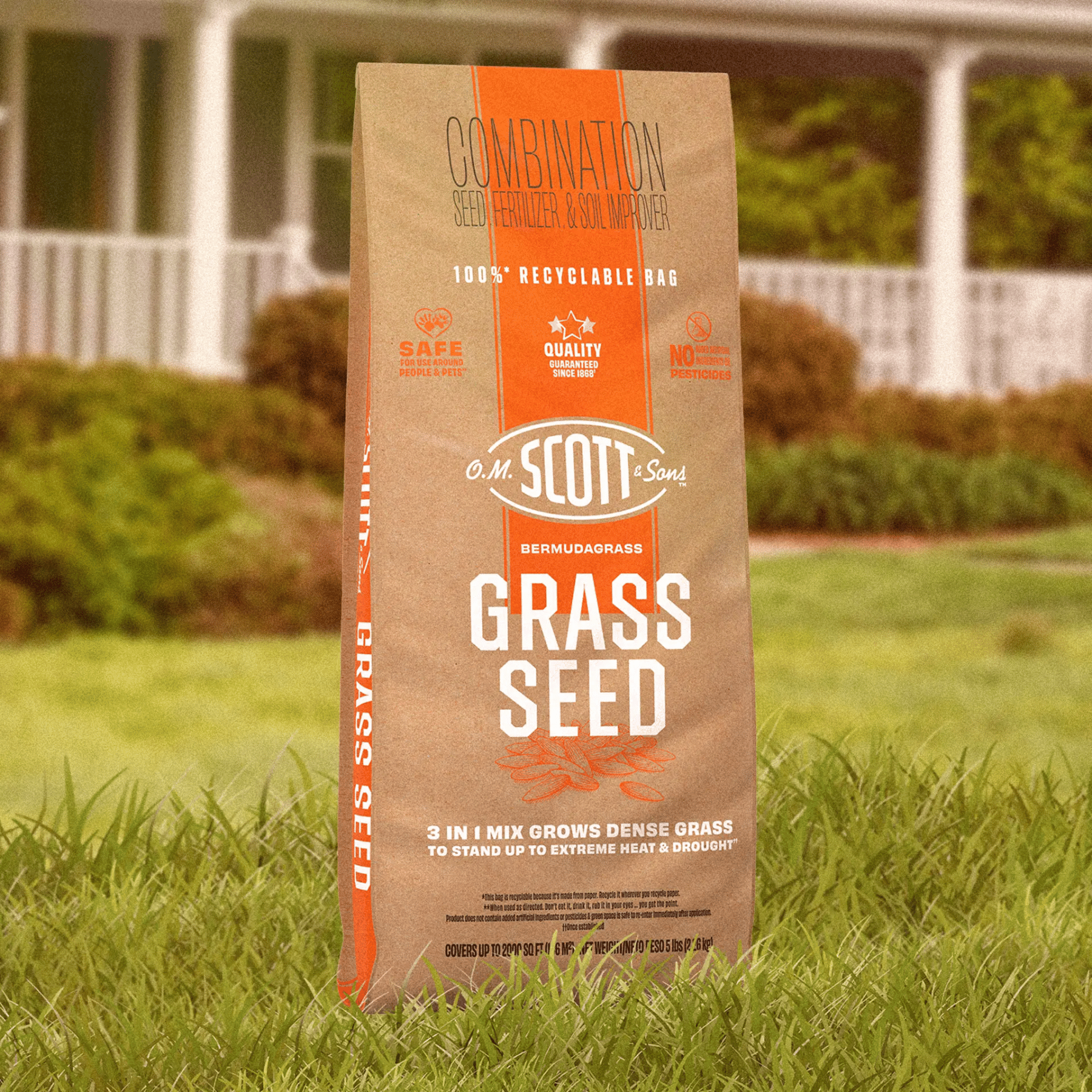 A brown bag of O.M. Scott & Sons Bermuda Grass Seed, Fertilizer & Soil Improver stands in green grass.