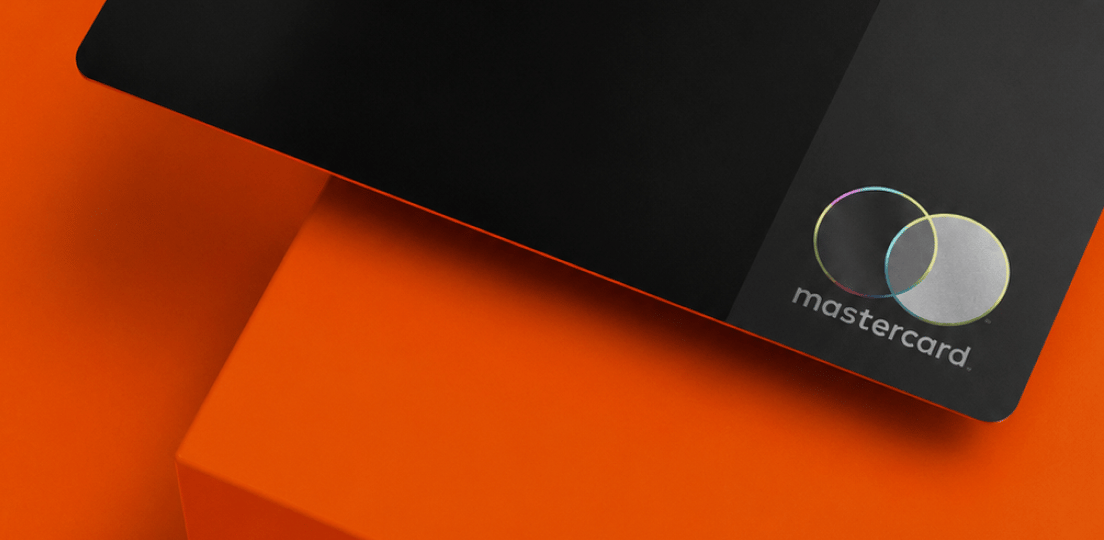A black credit card on an orange background