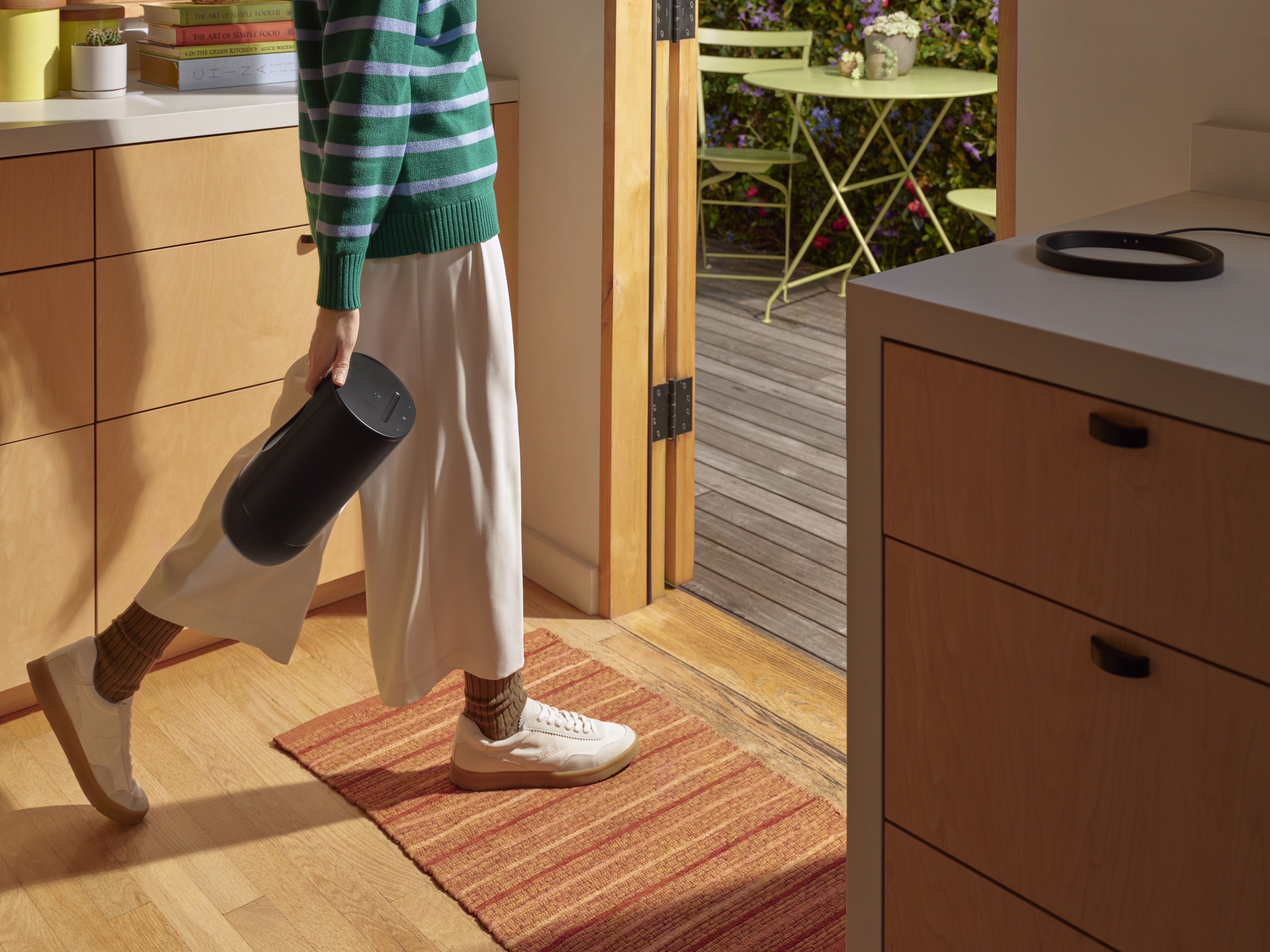 Two people dancing with a portable Sonos speaker