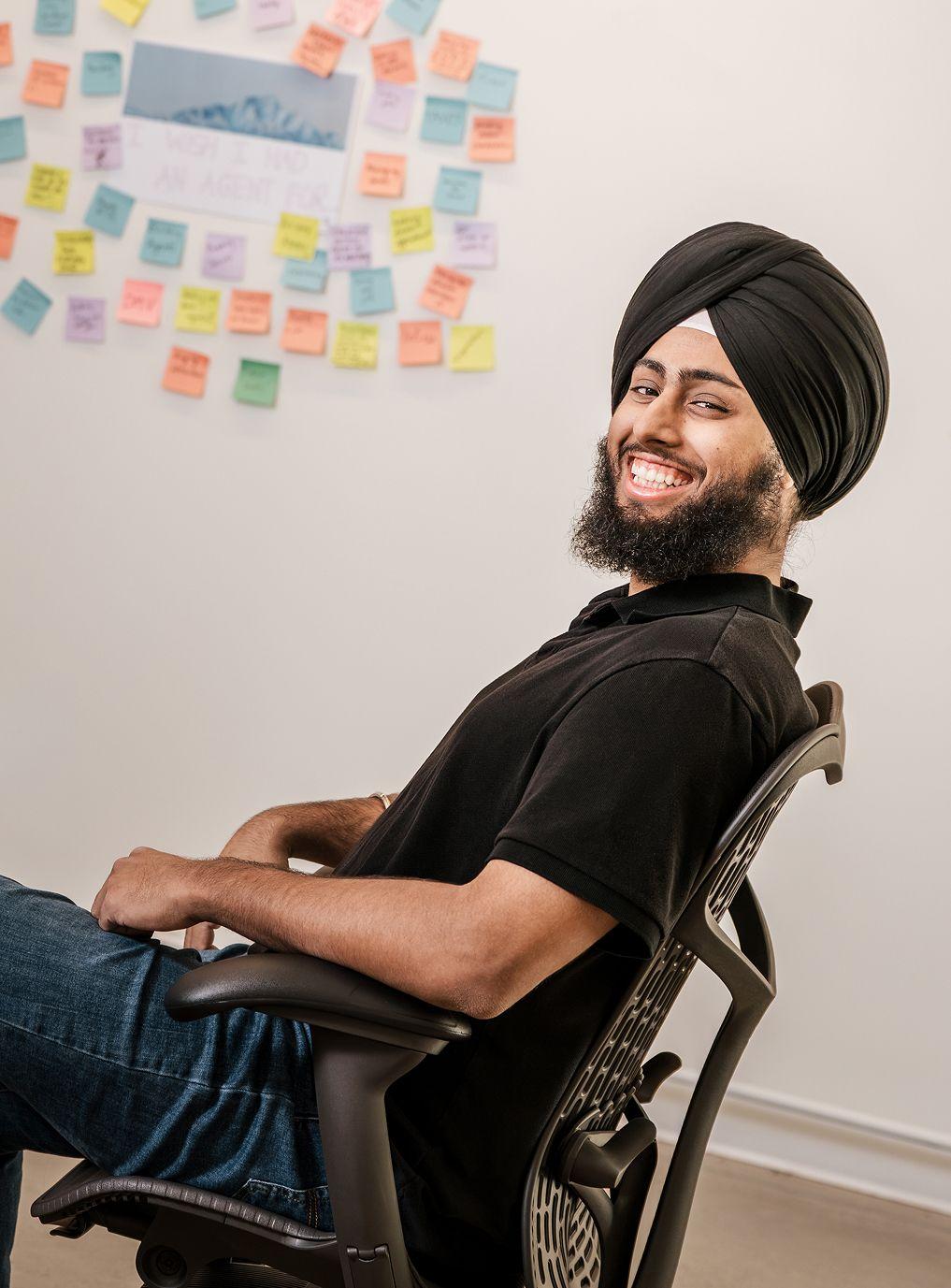 Man sitting in desk chair with post-its behind him