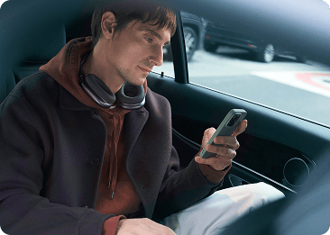 Man looks at his phone in a car.