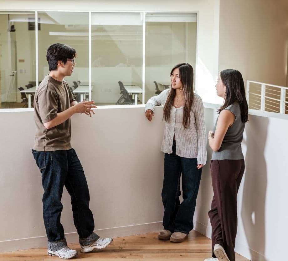 one man and two women chatting hanging out